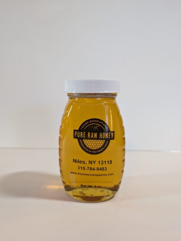 A jar of honey on top of a table.