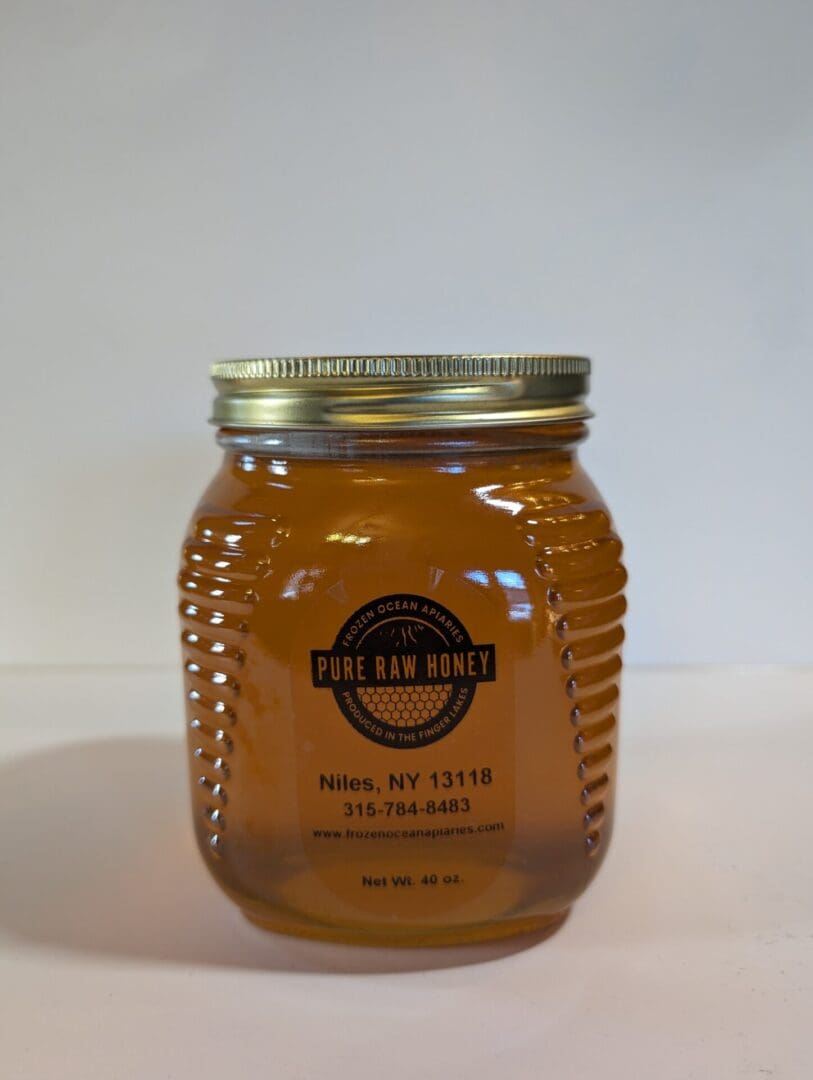 A jar of honey on top of a table.