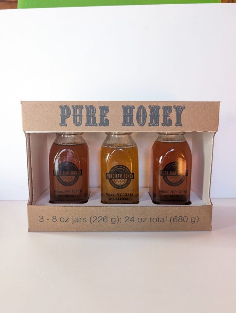 A box of honey is shown with three different jars.