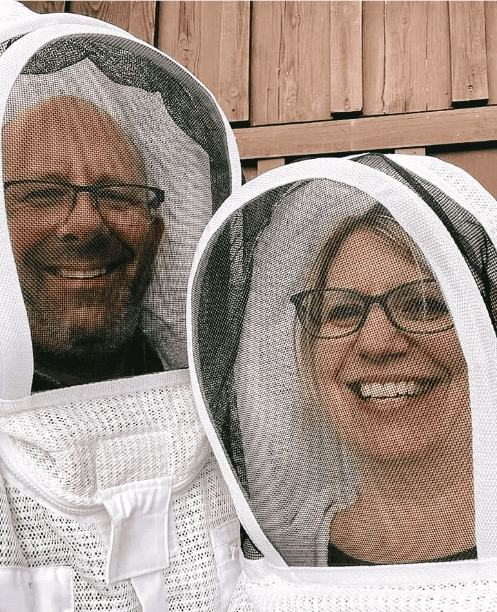 A man and woman wearing white clothing with veil over them.
